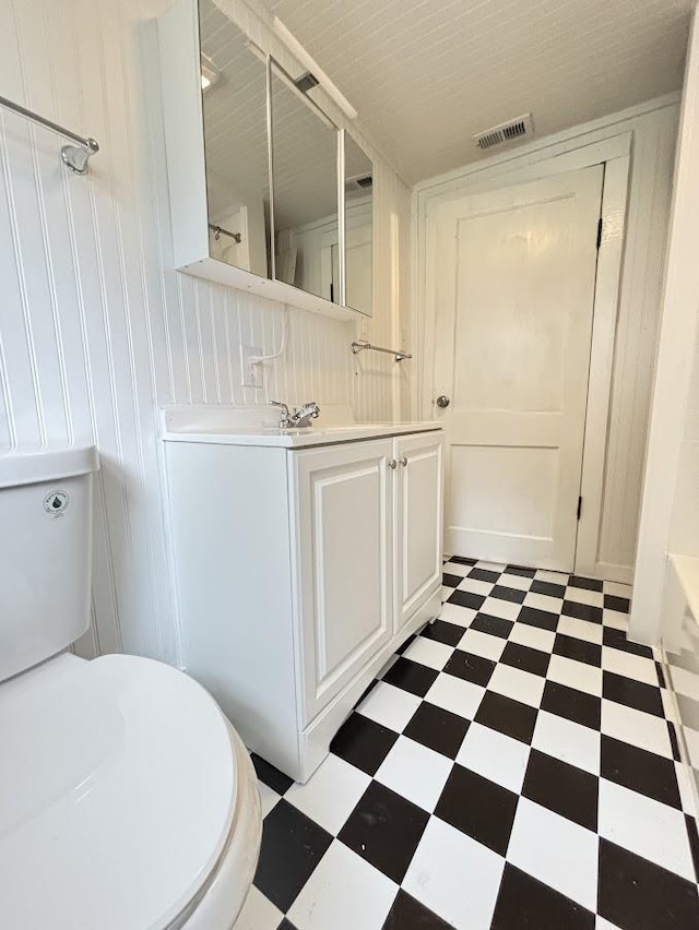 full bath featuring toilet, vanity, visible vents, and tile patterned floors