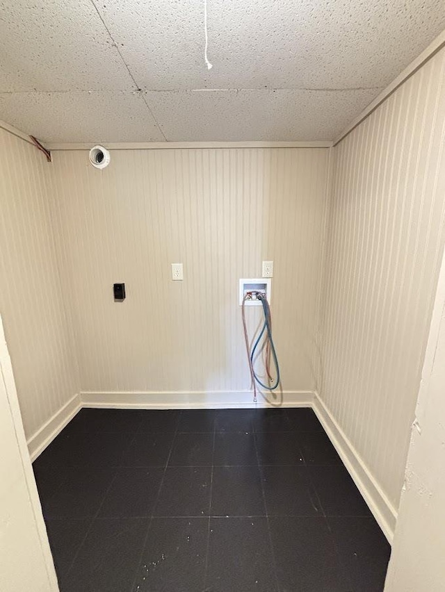 laundry room with hookup for a washing machine, baseboards, laundry area, and dark tile patterned flooring