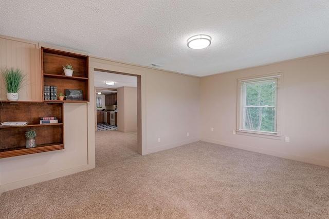  - spare room with carpet, a textured ceiling, and baseboards