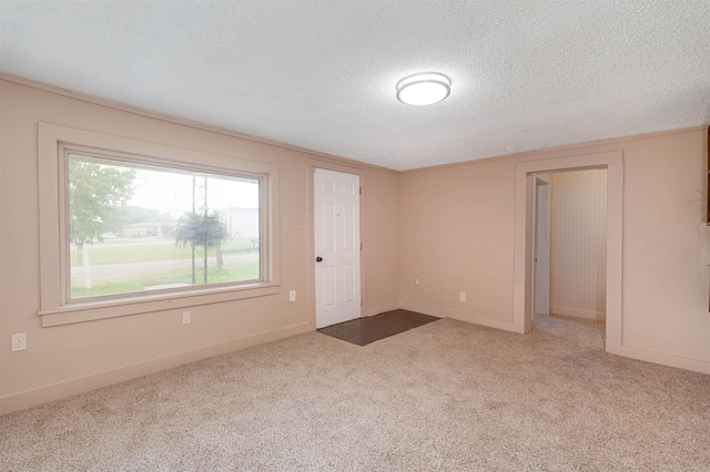  - spare room with a textured ceiling, carpet floors, and baseboards
