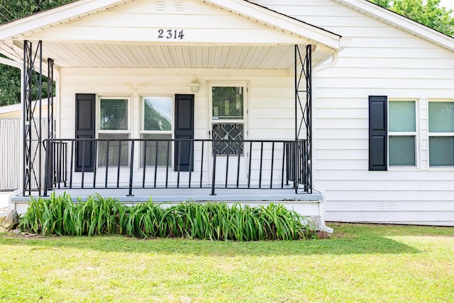 view of side of home featuring a porch and a yard