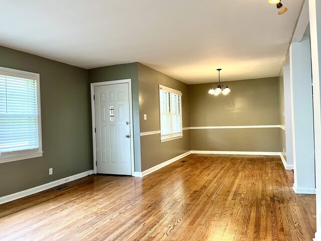 entrance foyer featuring hardwood / wood-style floors and a chandelier