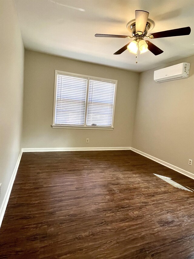 spare room with dark hardwood / wood-style flooring, a wall mounted AC, and ceiling fan