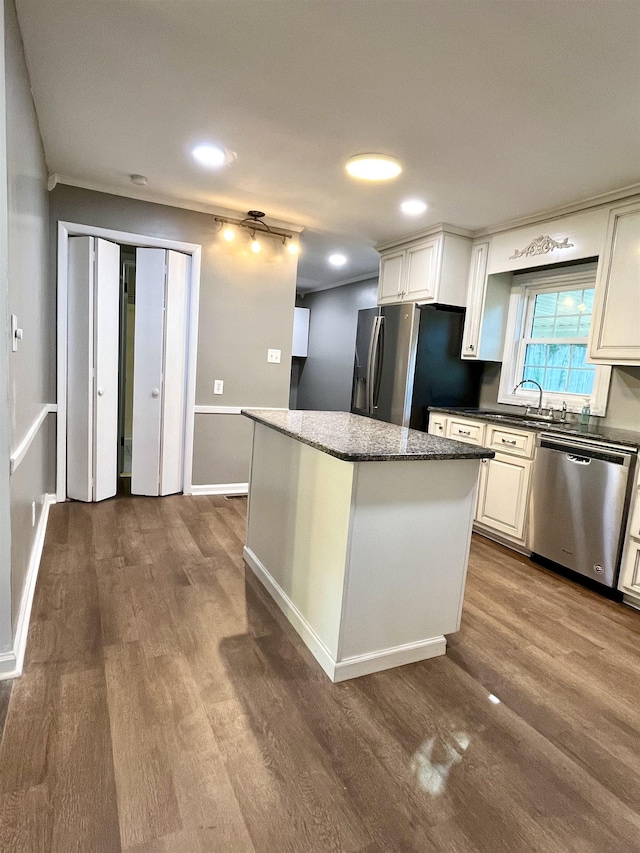 kitchen featuring white cabinets, a center island, wood-type flooring, and stainless steel appliances