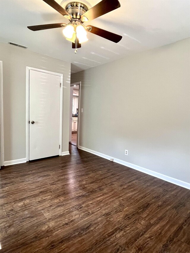 unfurnished bedroom with ceiling fan, dark hardwood / wood-style flooring, and a closet