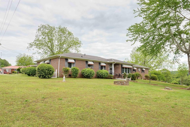view of front facade with brick siding and a front yard