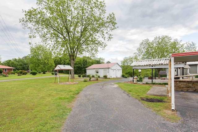 view of property's community with a lawn, an outdoor structure, and a garage