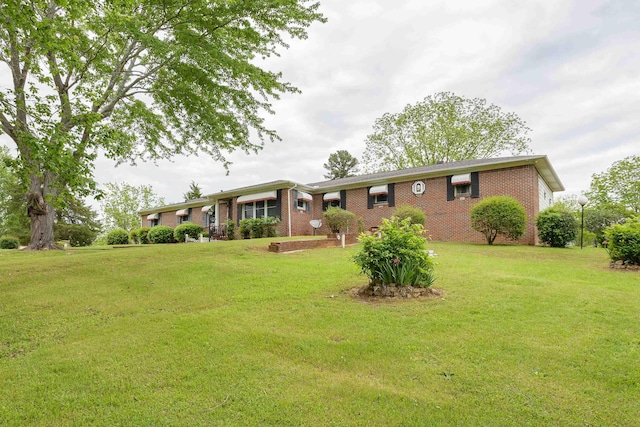 view of front of house featuring brick siding and a front lawn