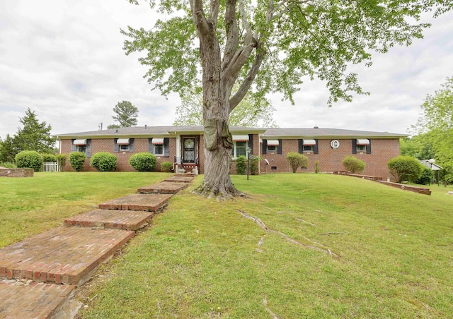 ranch-style house featuring brick siding and a front lawn