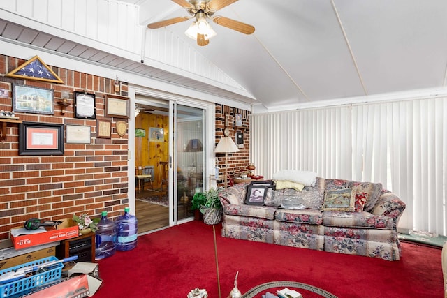 living room with brick wall, a ceiling fan, vaulted ceiling, and carpet