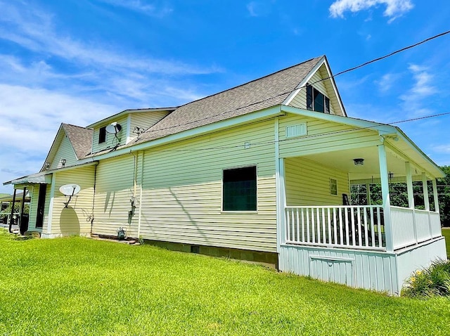 view of side of property with a lawn and covered porch