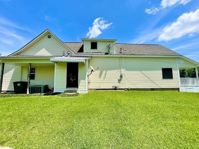 back of property featuring a lawn and central AC