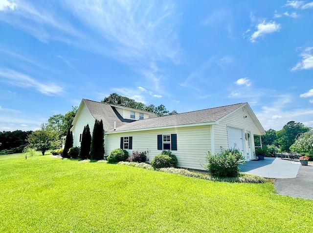 view of home's exterior with a garage and a lawn