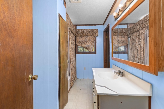 bathroom featuring crown molding, vanity, a textured ceiling, and walk in shower