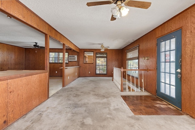 carpeted entryway with a textured ceiling, plenty of natural light, and ceiling fan