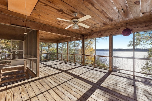 unfurnished sunroom with ceiling fan, a healthy amount of sunlight, a water view, and wood ceiling