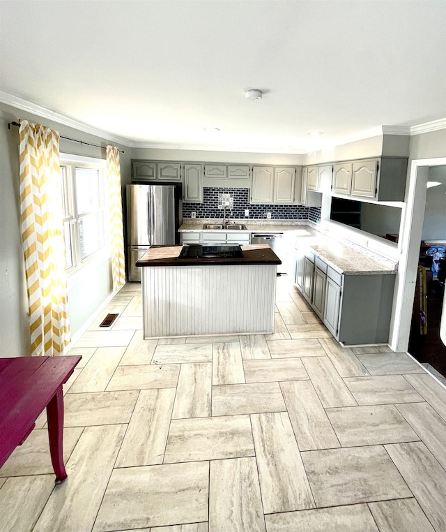 kitchen with visible vents, backsplash, gray cabinetry, crown molding, and stainless steel appliances