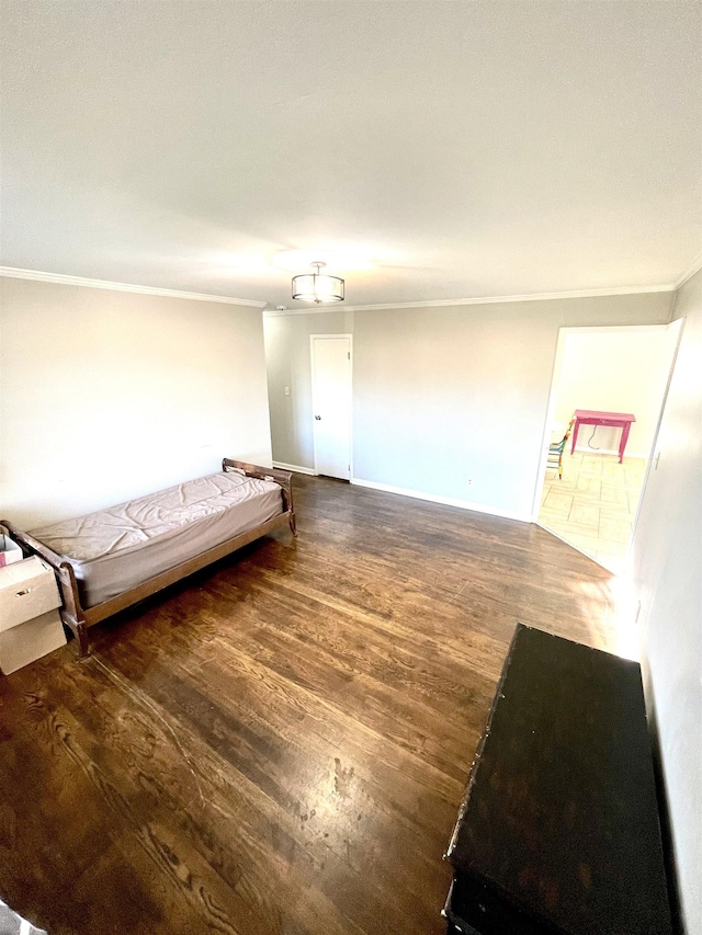 unfurnished bedroom with baseboards, wood finished floors, and ornamental molding