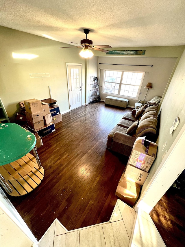 living room featuring baseboards, a textured ceiling, a ceiling fan, and hardwood / wood-style flooring