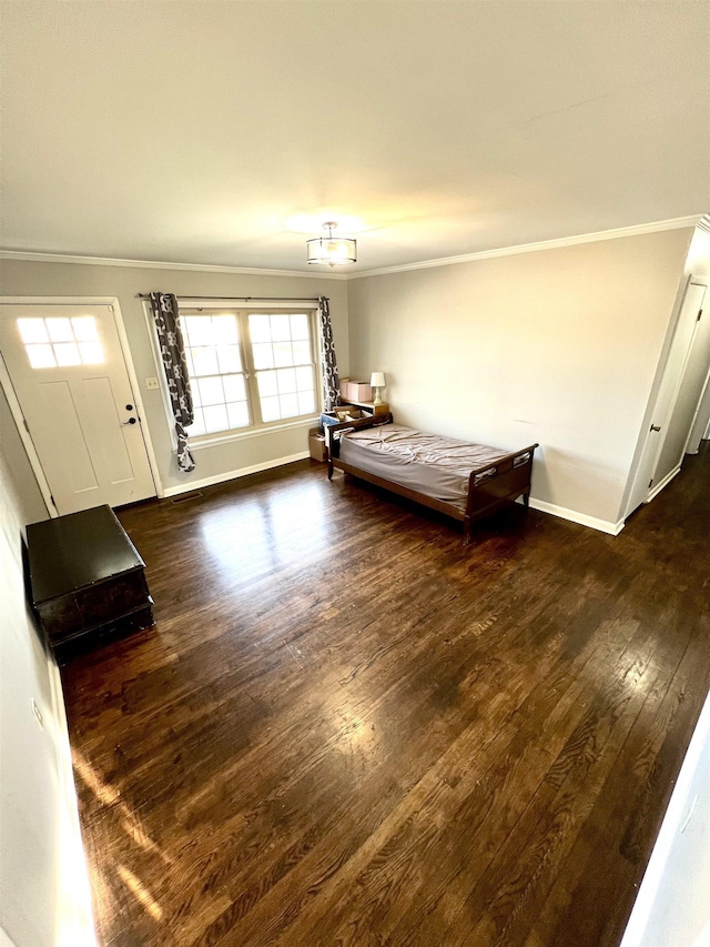 unfurnished bedroom with crown molding, wood finished floors, and baseboards