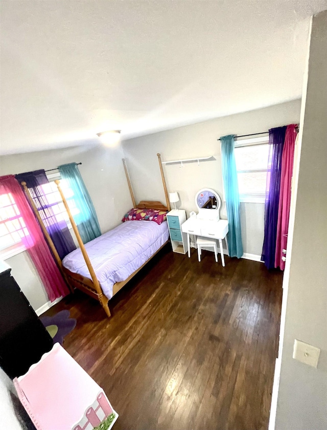 bedroom featuring baseboards and wood-type flooring