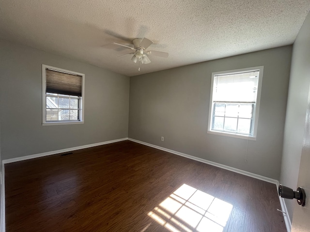 empty room featuring ceiling fan, a textured ceiling, and dark hardwood / wood-style floors