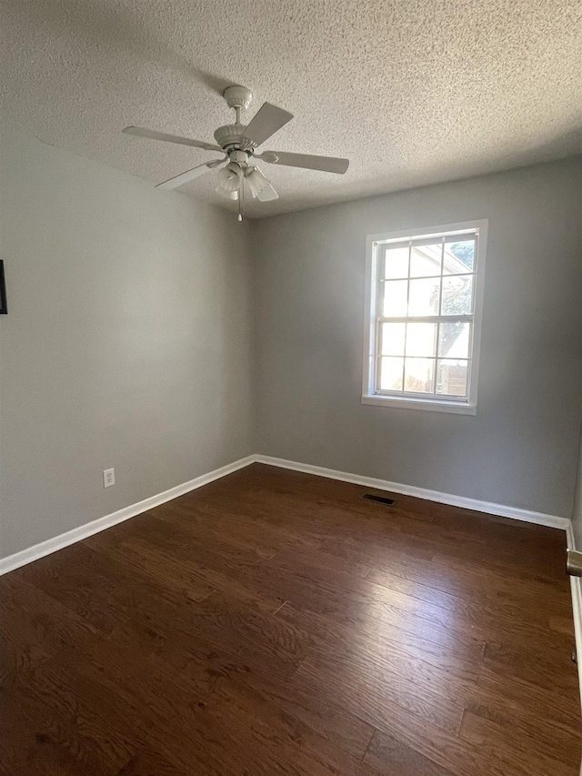 spare room with ceiling fan, dark wood-type flooring, and a textured ceiling