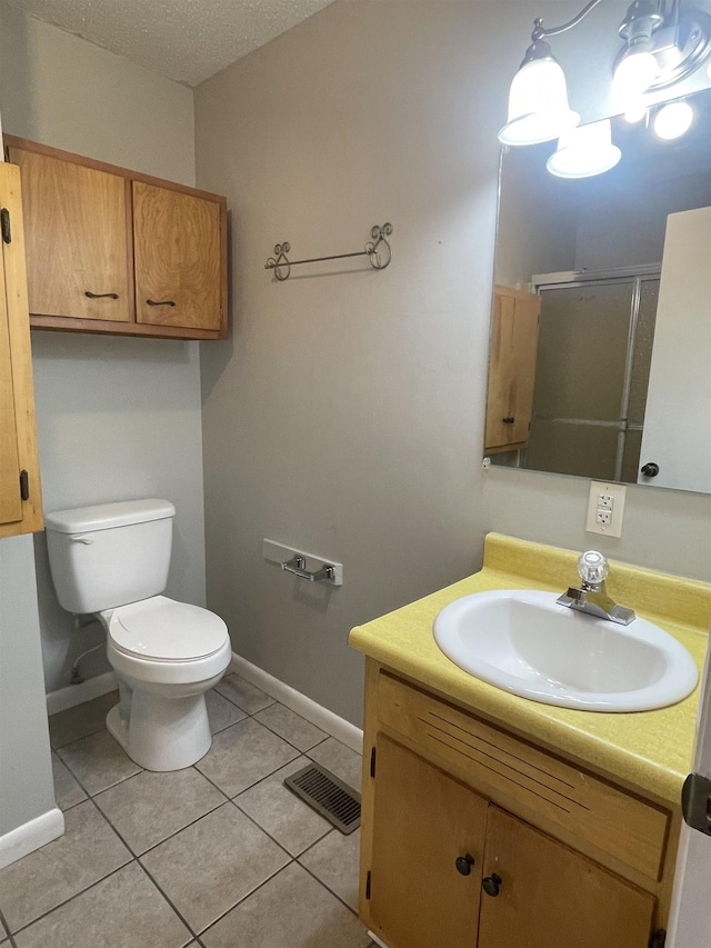 bathroom with toilet, vanity, walk in shower, and tile patterned flooring