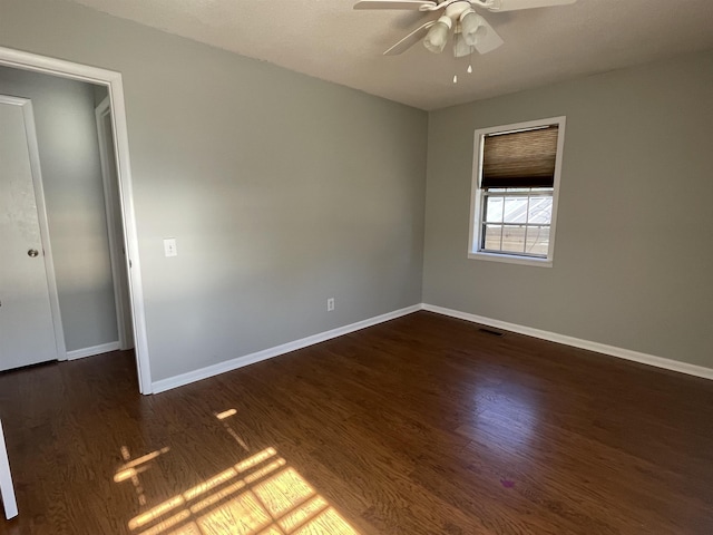 spare room with dark wood-type flooring and ceiling fan