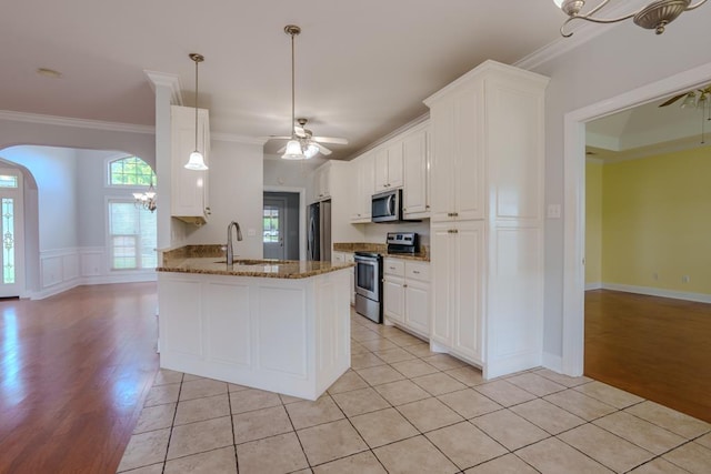 kitchen with kitchen peninsula, white cabinets, and appliances with stainless steel finishes