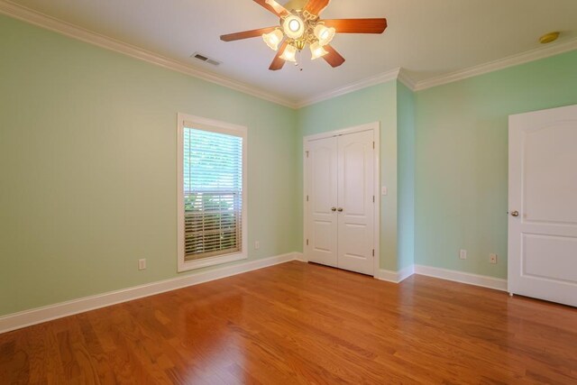 unfurnished bedroom featuring light wood-type flooring, a closet, ceiling fan, and ornamental molding