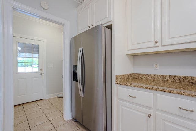 kitchen featuring light stone countertops, white cabinetry, stainless steel refrigerator with ice dispenser, and light tile patterned floors