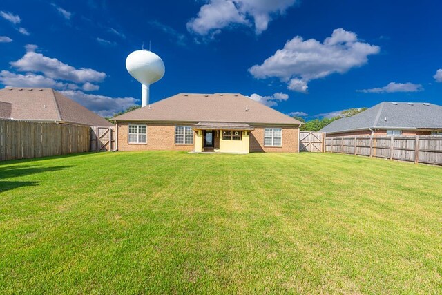 rear view of property featuring a yard