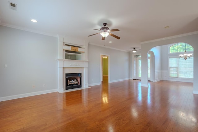 unfurnished living room featuring ceiling fan with notable chandelier, light hardwood / wood-style flooring, and ornamental molding