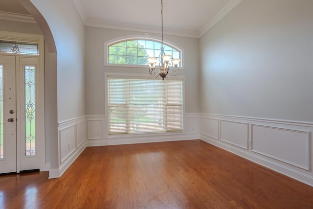 foyer with wood-type flooring, a chandelier, and ornamental molding