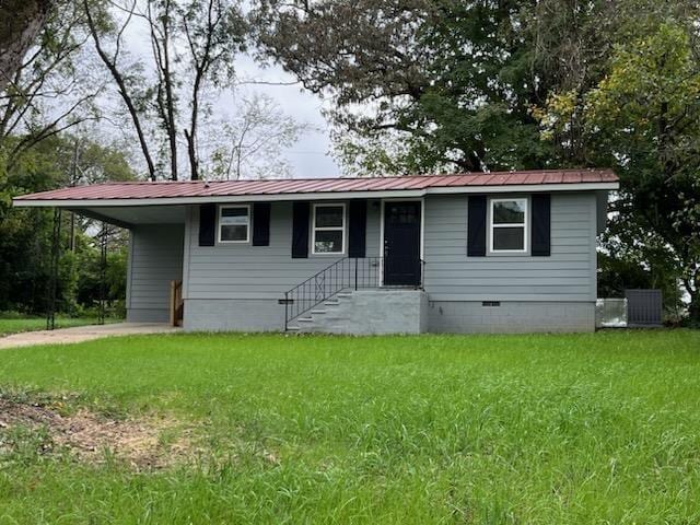 view of front of property with a carport and a front lawn