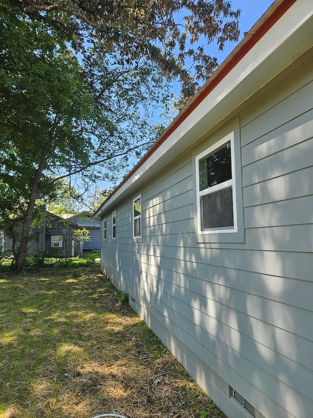 view of side of home with a yard