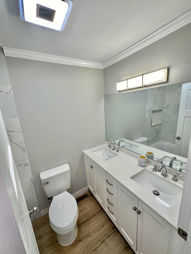 bathroom featuring vanity, toilet, wood-type flooring, and ornamental molding