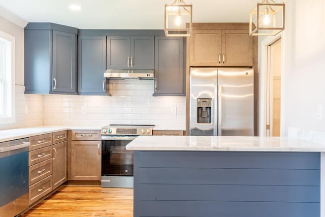 kitchen featuring decorative light fixtures, light stone countertops, decorative backsplash, and appliances with stainless steel finishes