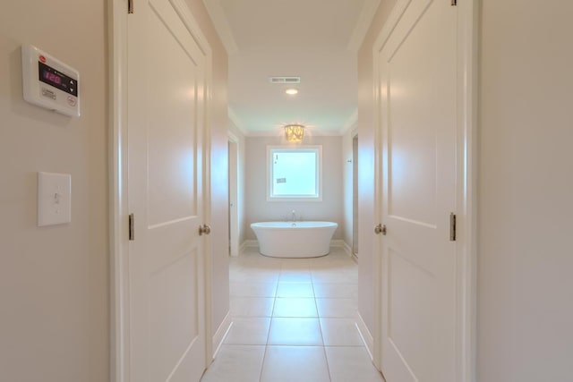 hall featuring crown molding and light tile patterned floors