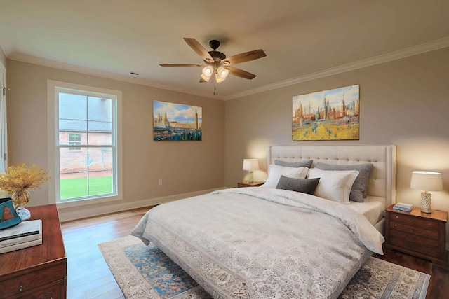 bedroom with hardwood / wood-style flooring, ceiling fan, and crown molding