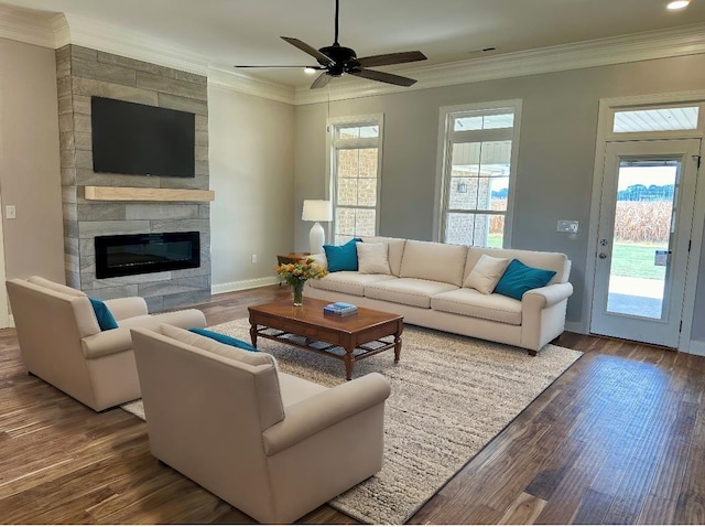 living room featuring crown molding, a tile fireplace, dark hardwood / wood-style floors, and ceiling fan