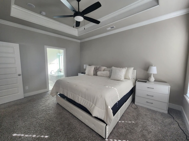 carpeted bedroom featuring ceiling fan, ensuite bathroom, crown molding, and a tray ceiling