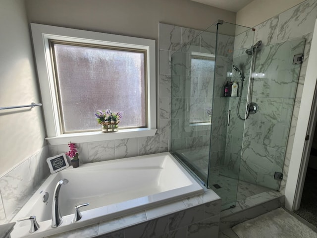 bathroom featuring separate shower and tub and a wealth of natural light