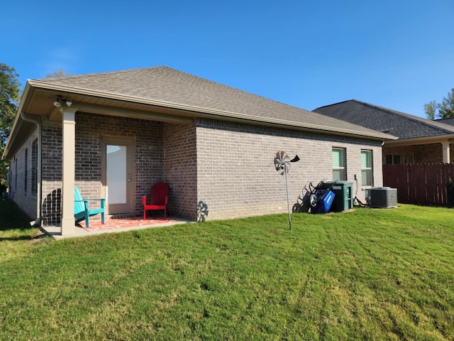 rear view of house featuring a yard and cooling unit