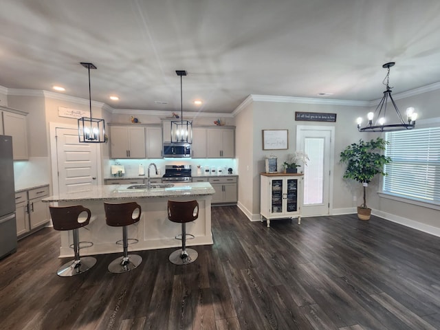 kitchen featuring sink, an island with sink, hanging light fixtures, and appliances with stainless steel finishes