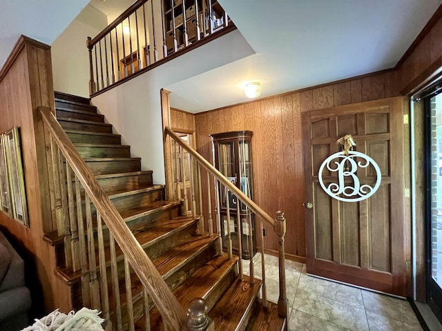 foyer entrance featuring stairs and wood walls
