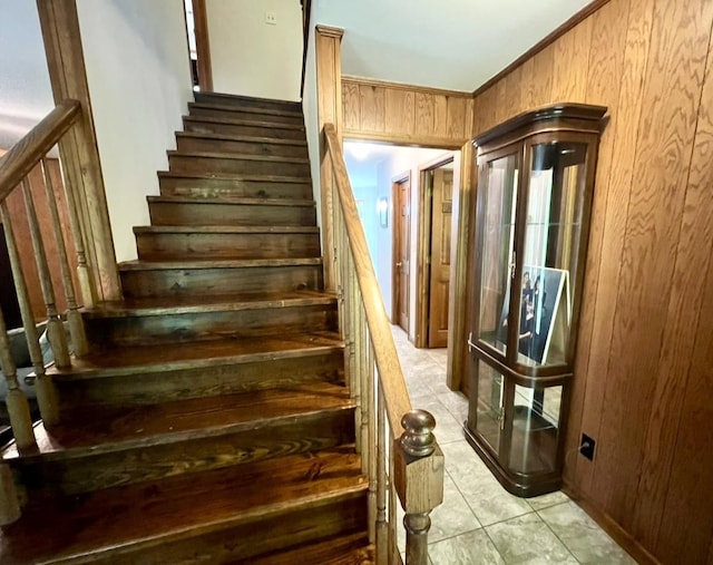 stairway featuring wooden walls and tile patterned floors