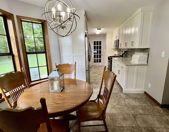 dining space featuring a chandelier, baseboards, and tile patterned floors