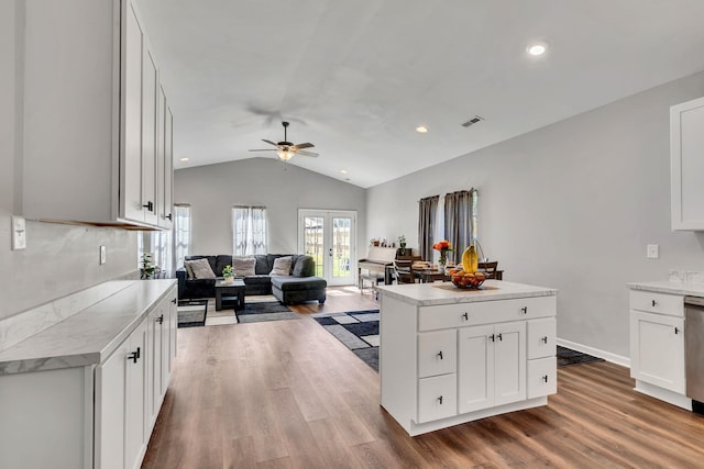 kitchen featuring vaulted ceiling, visible vents, light countertops, and wood finished floors